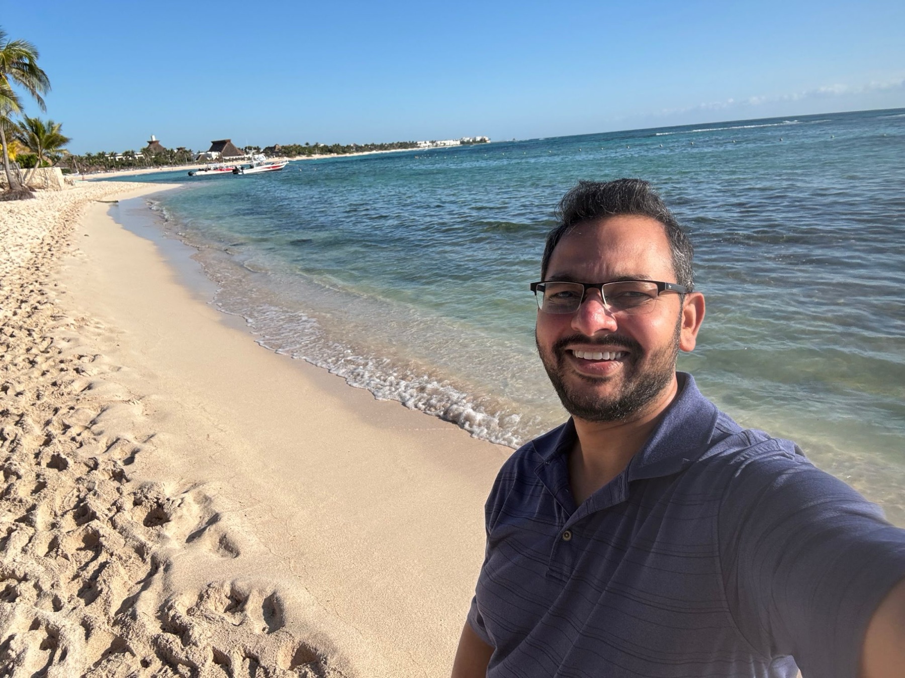 Rafi smiling on a sunny beach